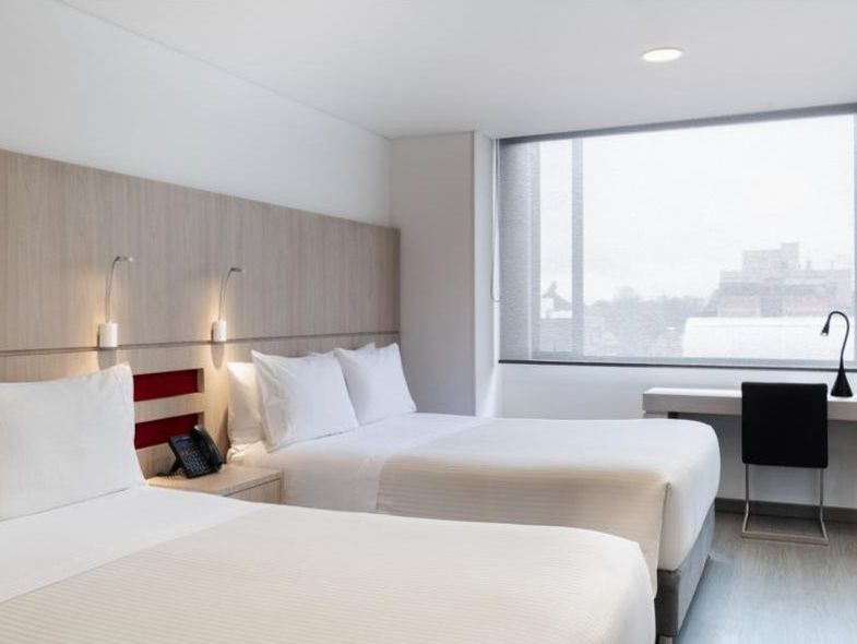 Standard room with queen bed, warm tones and marble en-suite